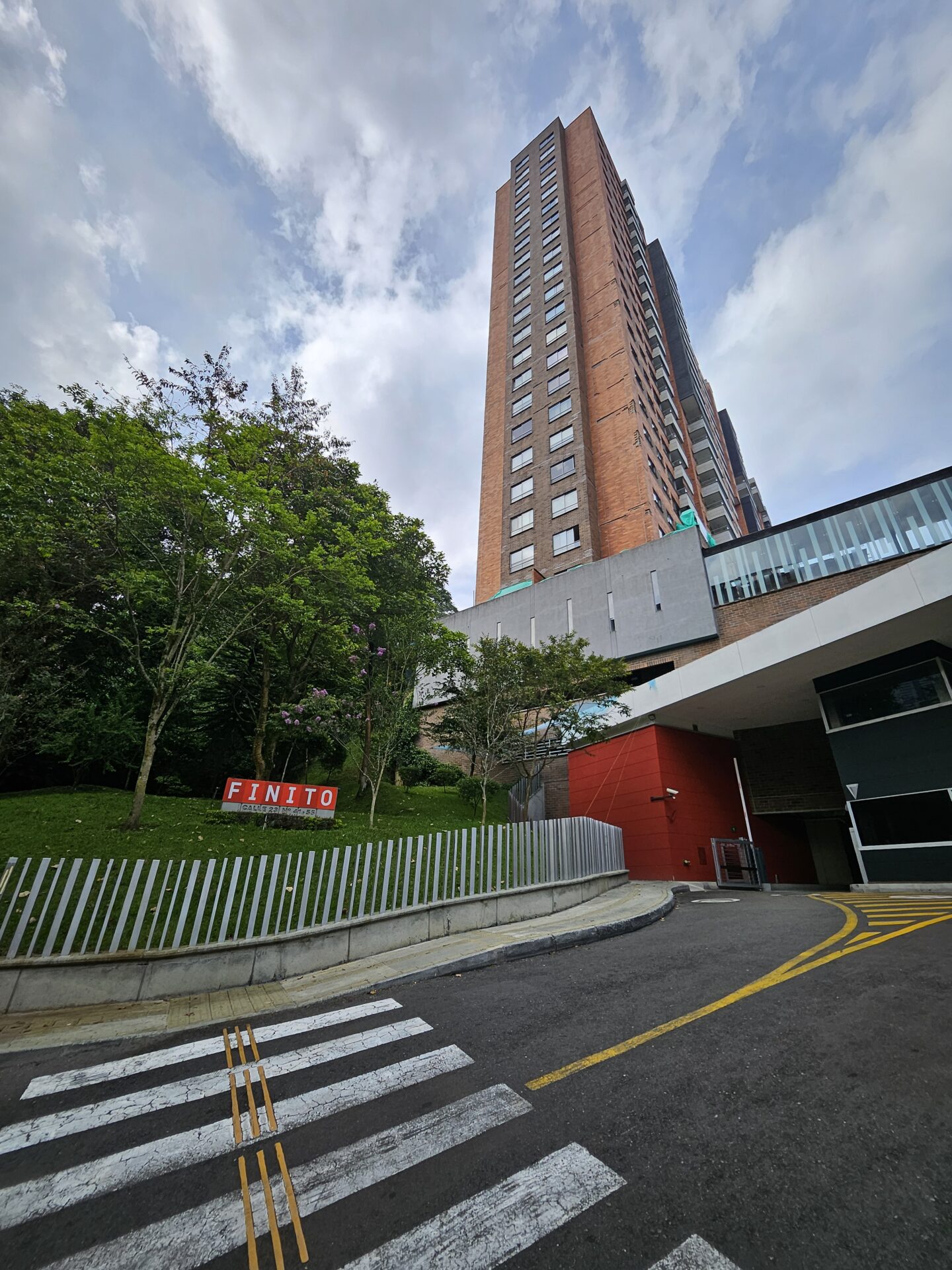 a tall building with a fence and trees
