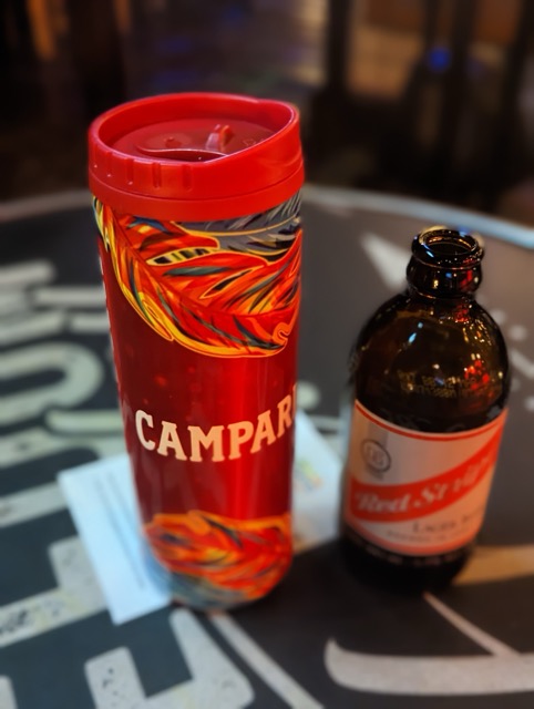 a red cup next to a brown bottle