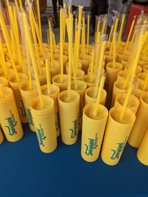 a group of yellow straws in plastic containers