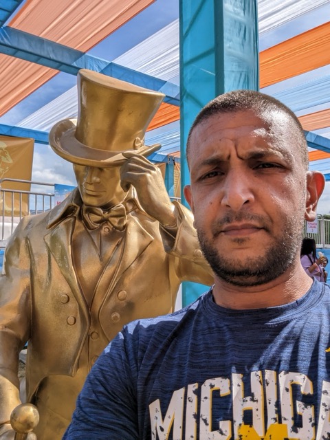 a man taking a selfie in front of a statue