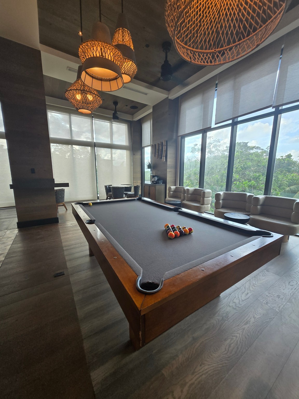 a pool table in a room with a couch and chairs