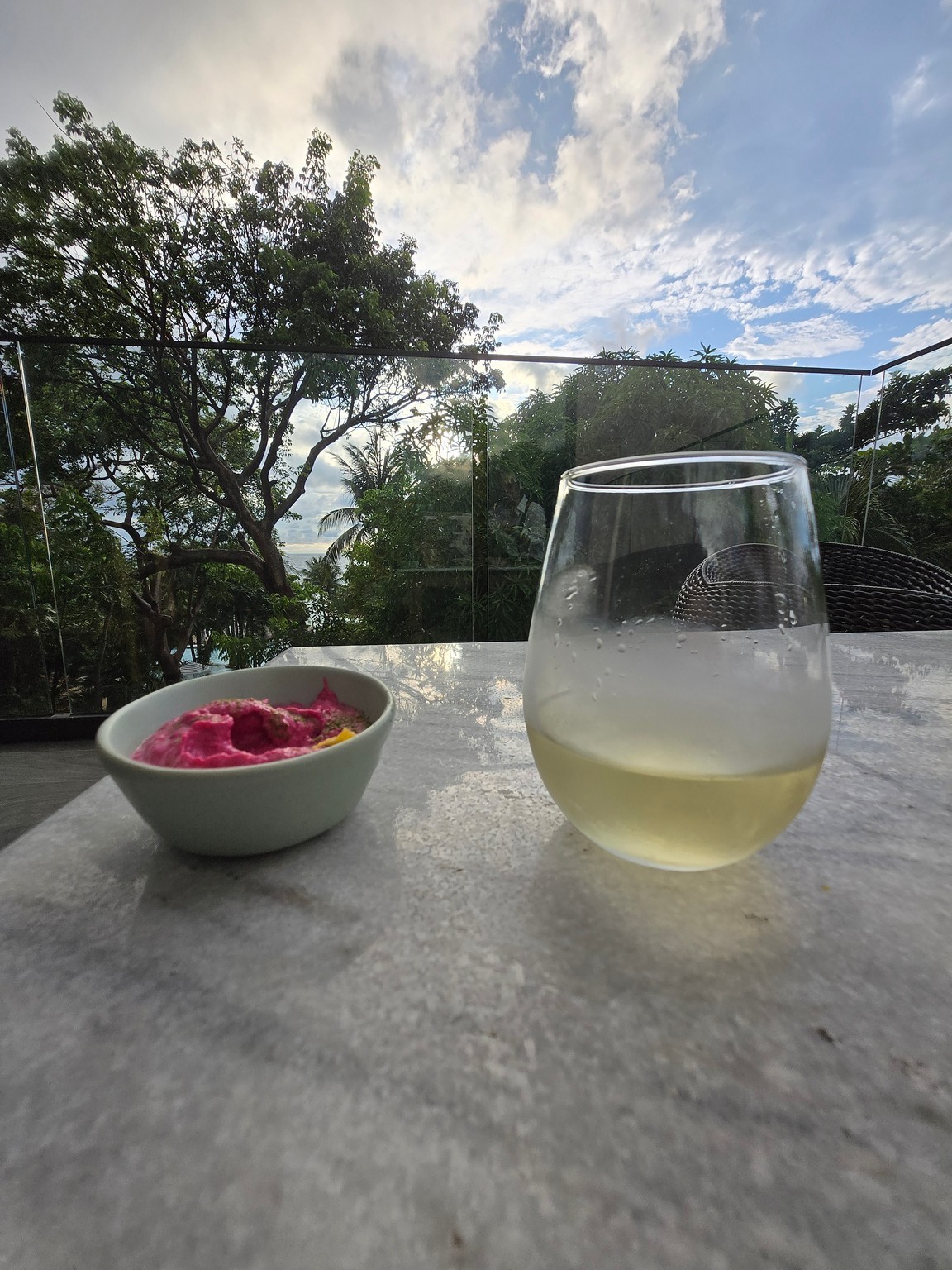 a glass of wine and a bowl of food on a table