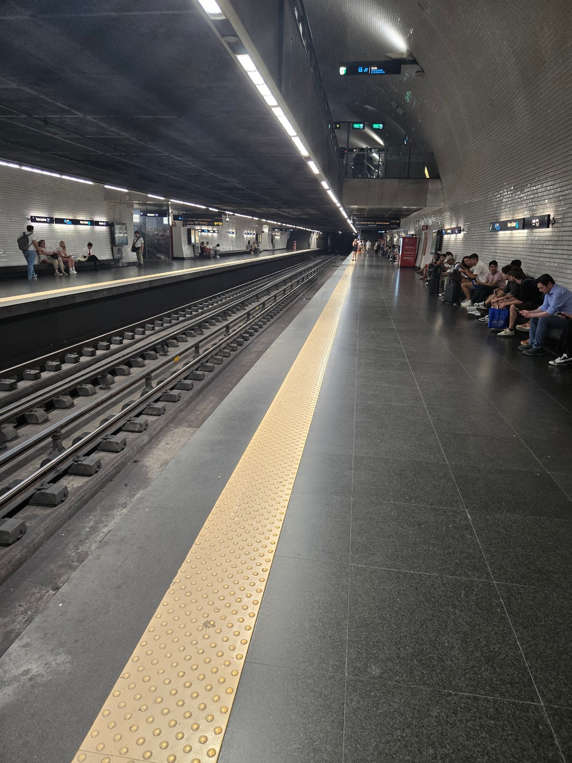 people sitting on a bench in a subway station