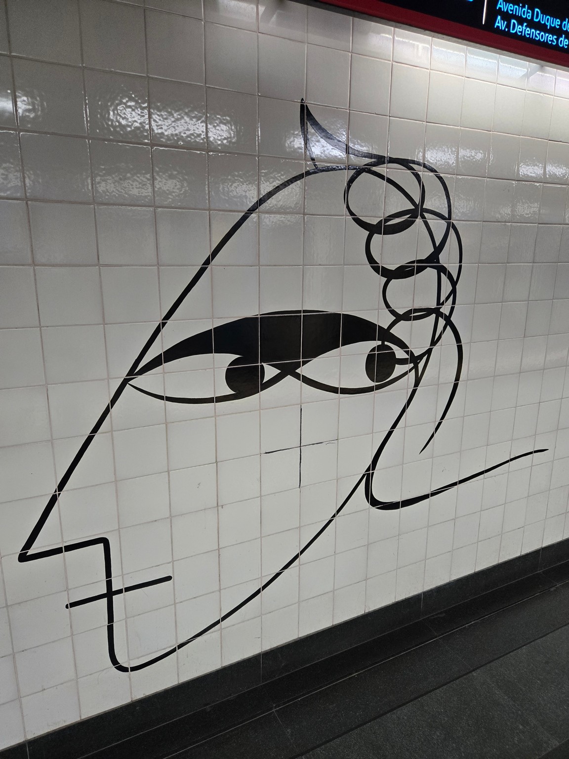 a drawing of a woman's face on a tile wall