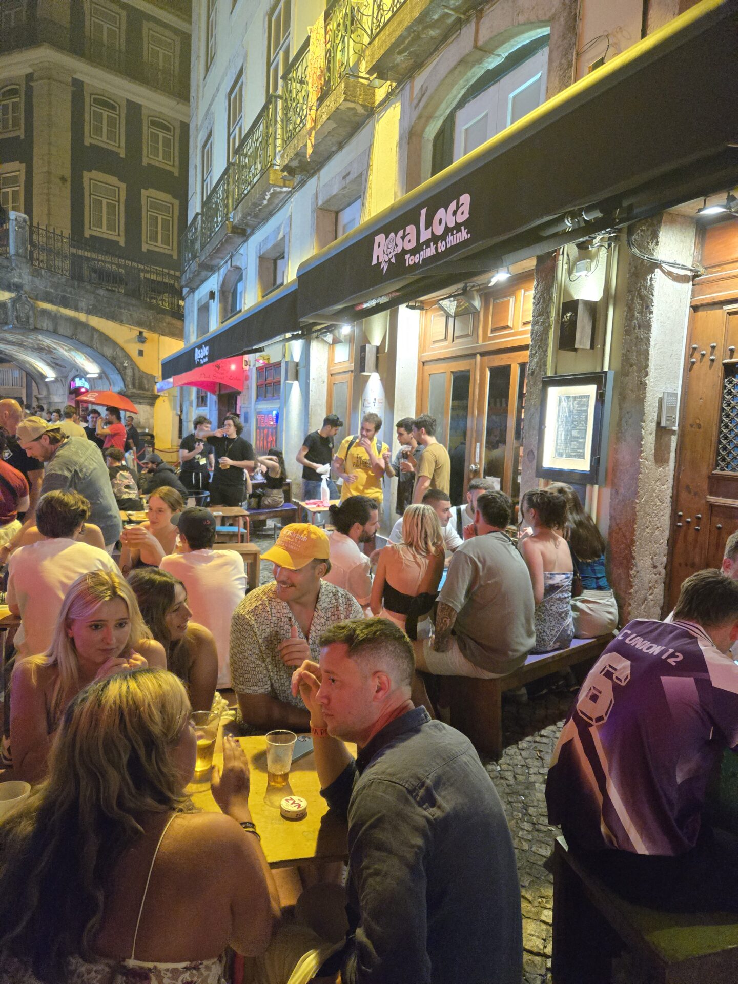 a group of people sitting at tables outside a restaurant