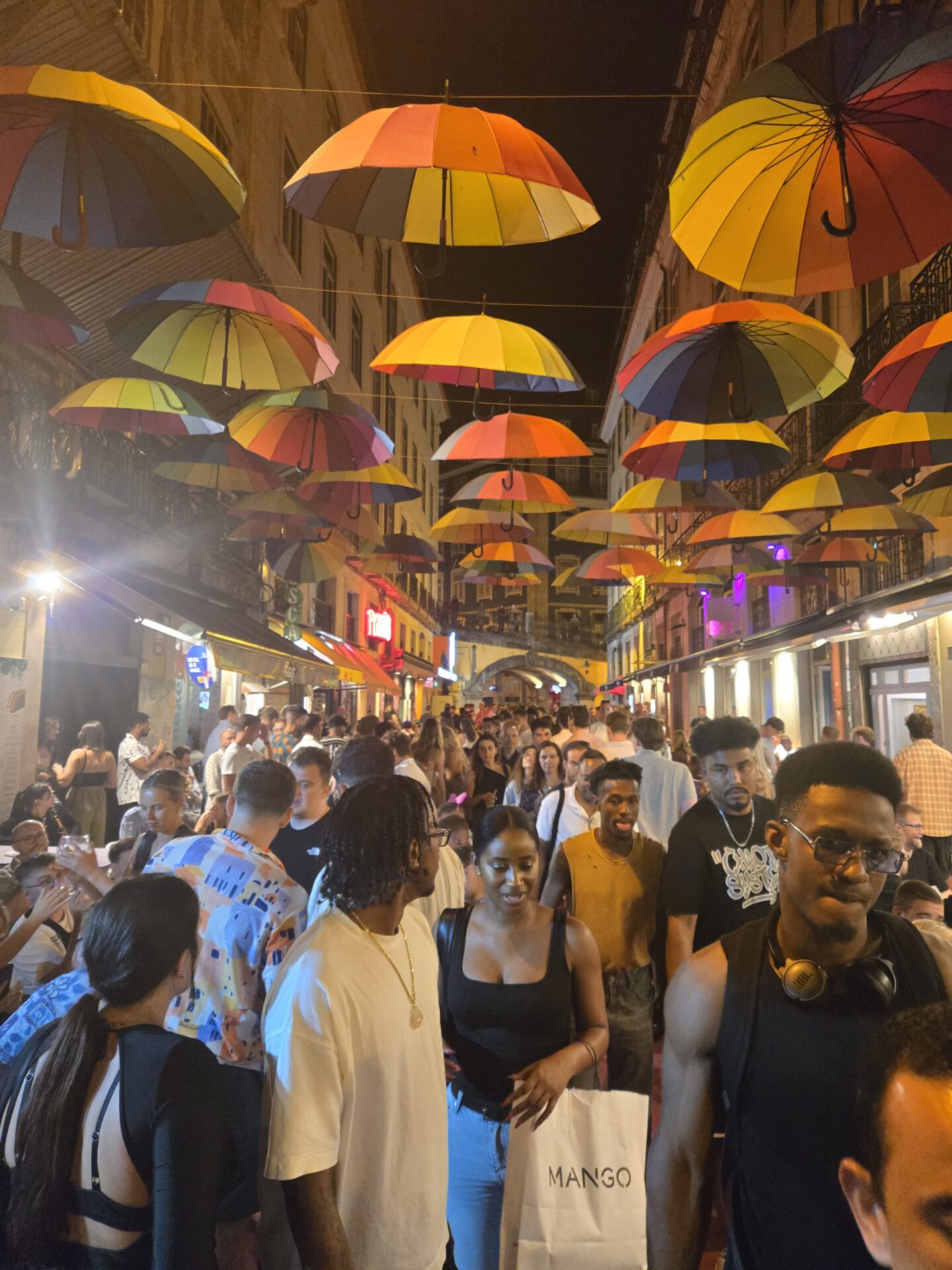 a group of people walking in a street with umbrellas with Grand Bazaar, Istanbul in the background