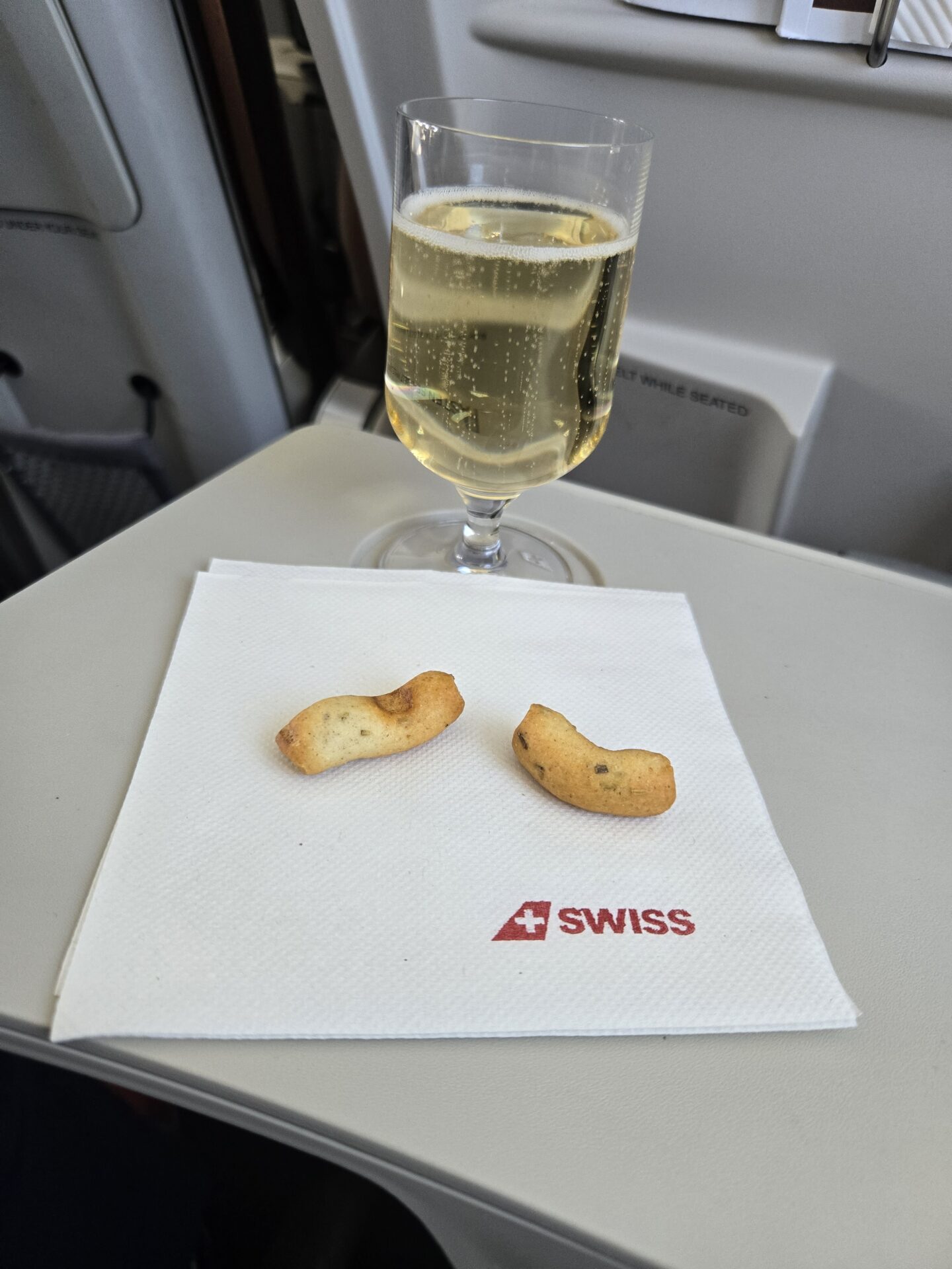 a glass of champagne and a pair of crackers on a napkin