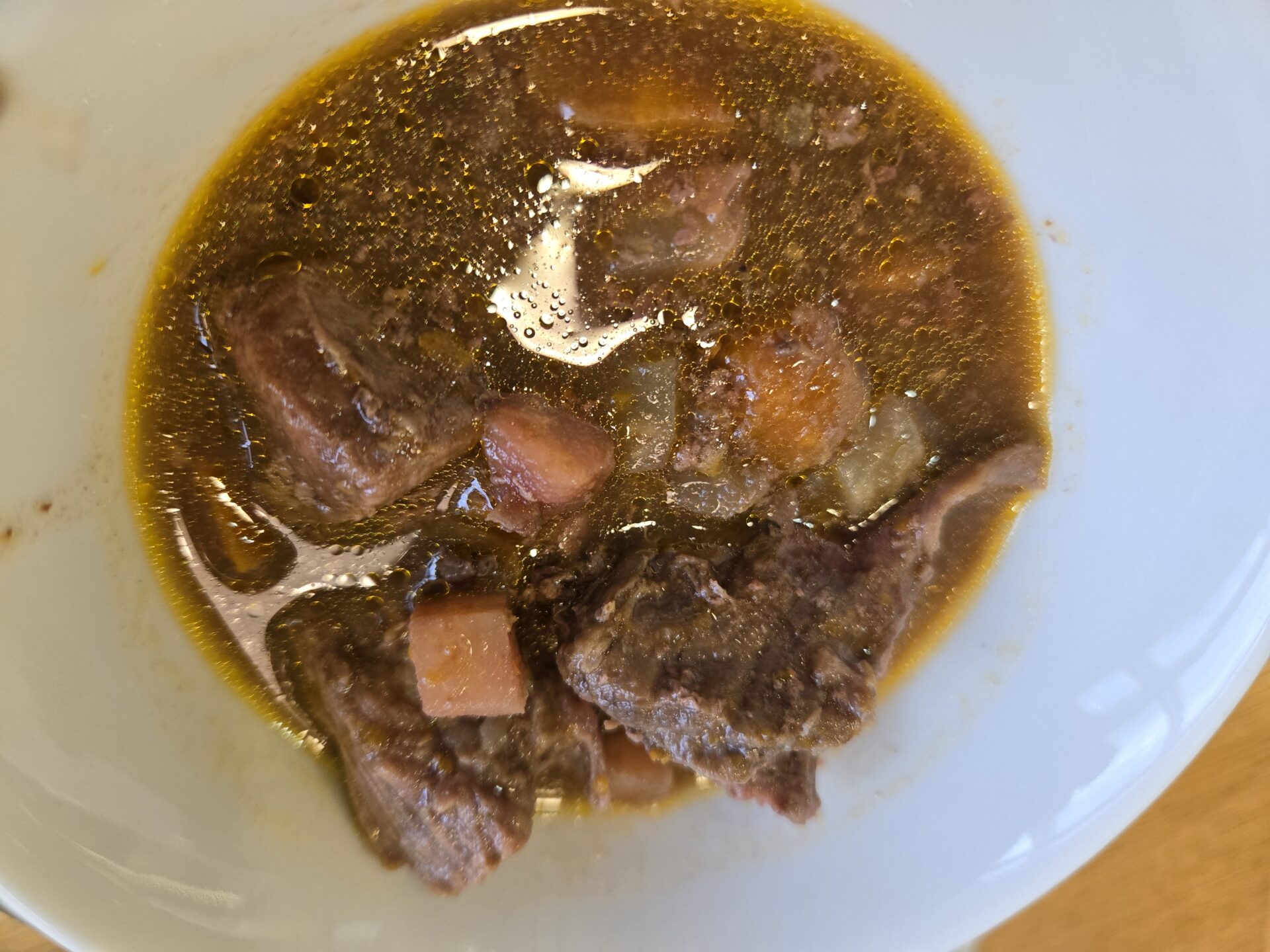 a bowl of soup with meat and vegetables