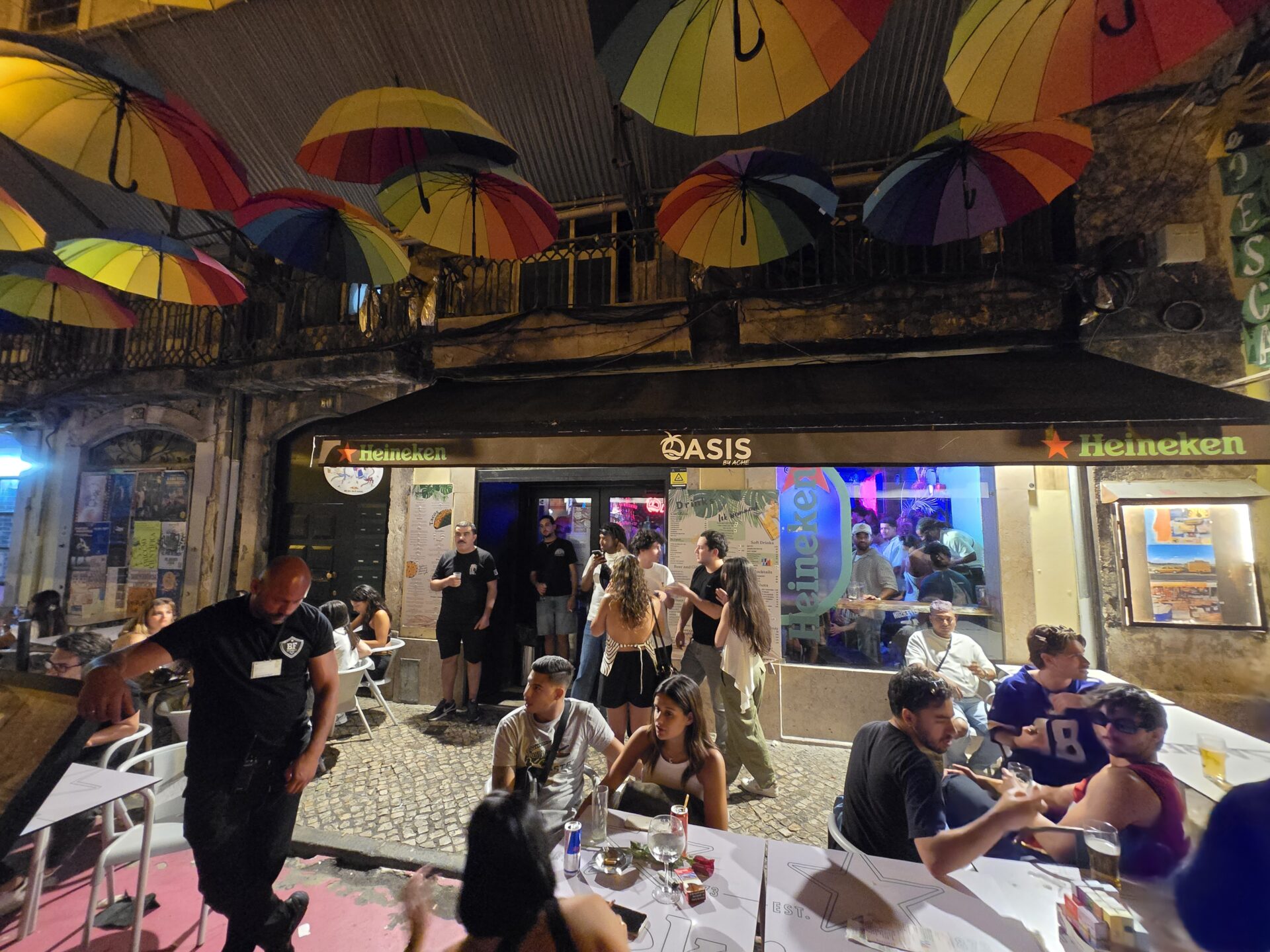 a group of people sitting around tables with umbrellas