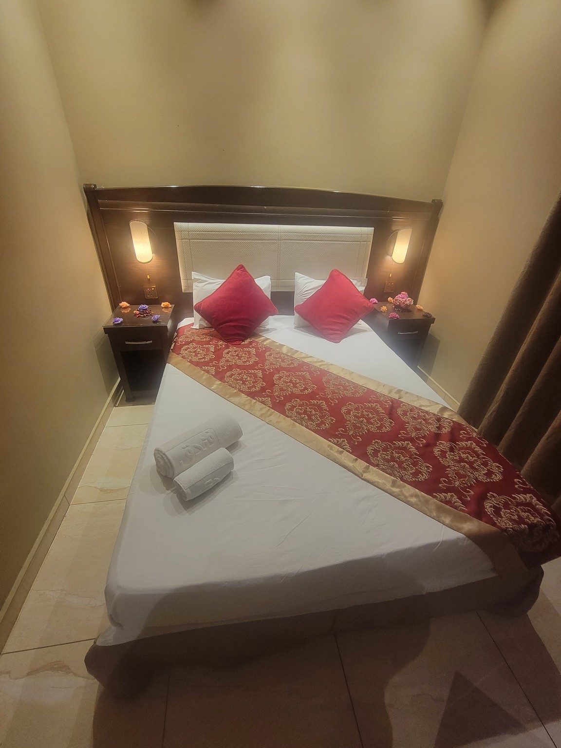 a bed with red pillows and a red and gold blanket