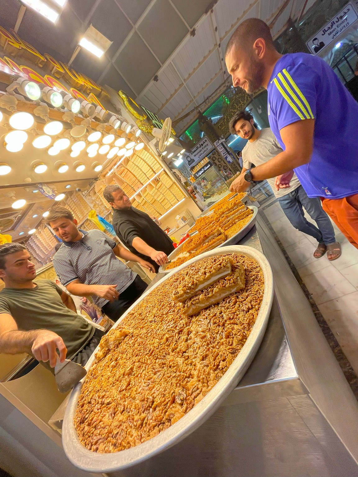a group of men standing around a large tray of food