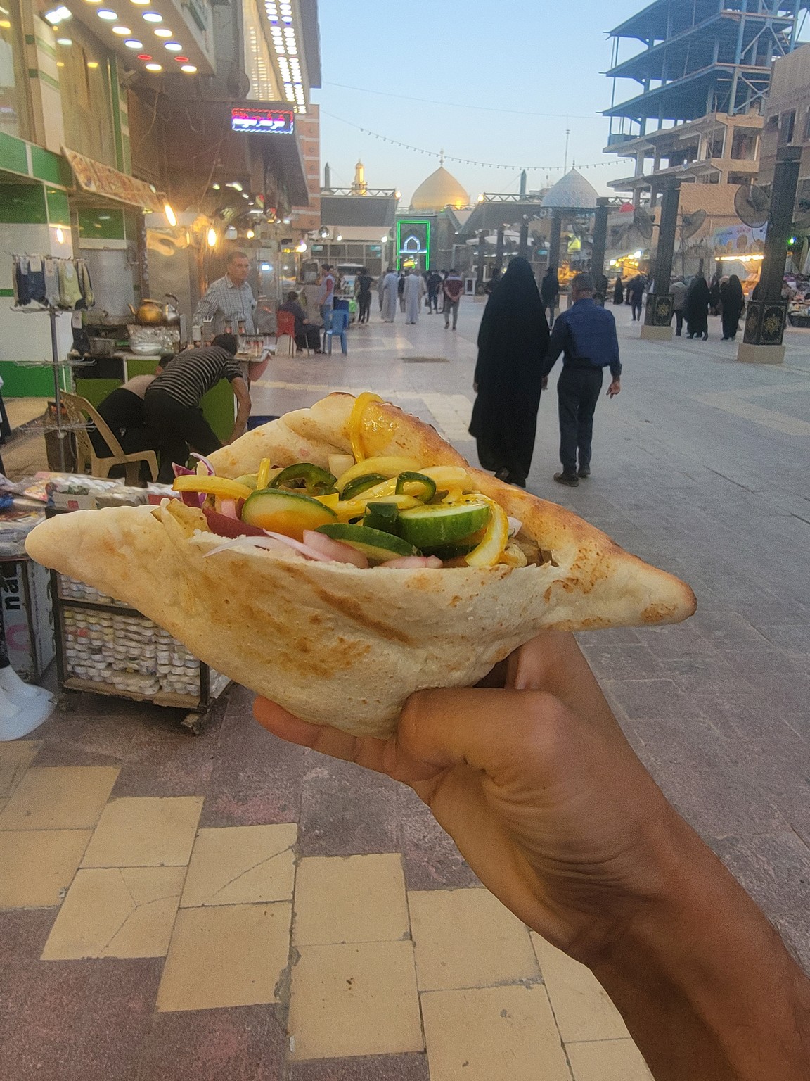 a hand holding a sandwich