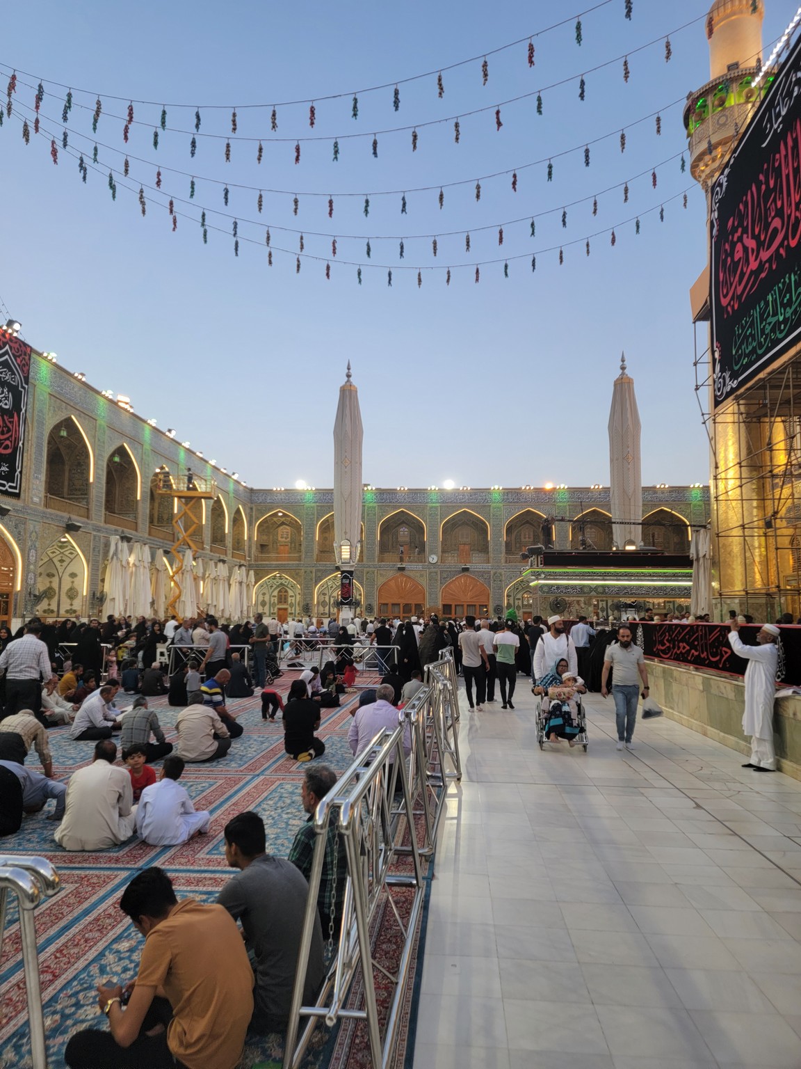 a group of people sitting on the ground in a courtyard