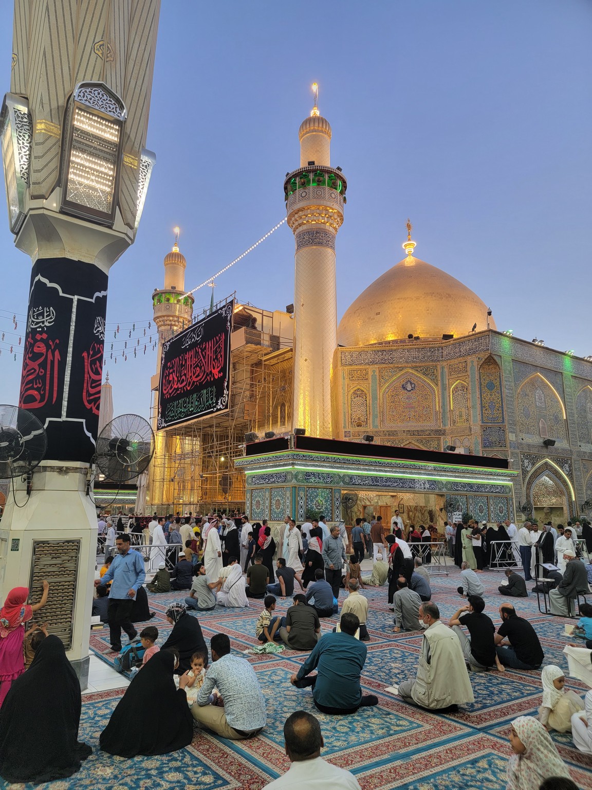 a group of people sitting on the ground in front of a building