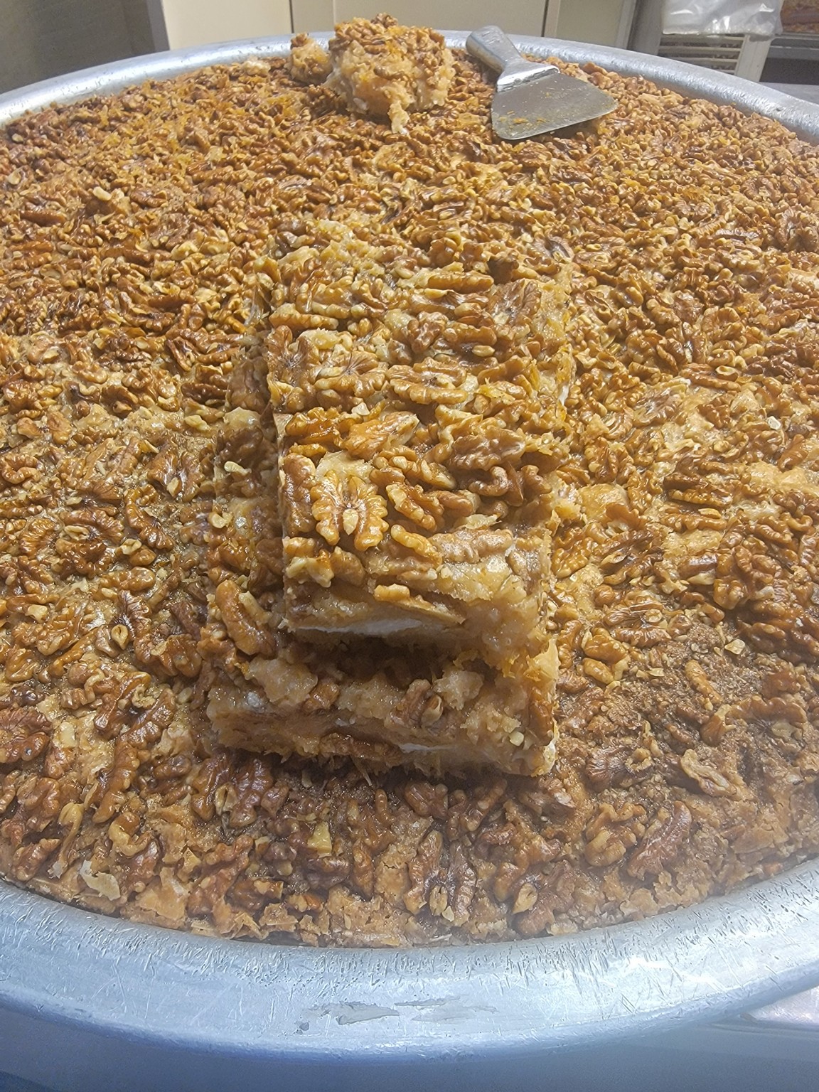 a large round dish with a pile of pecan pie