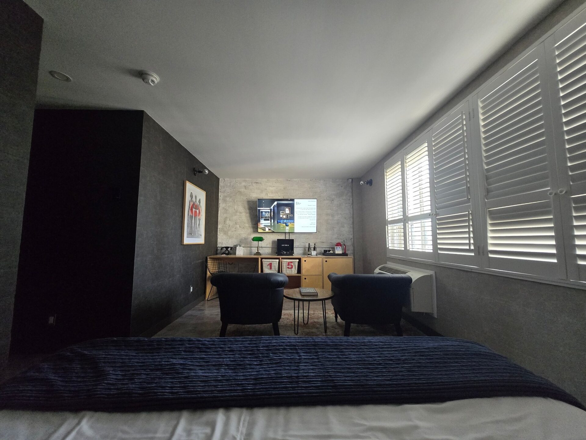 a room with a bed and chairs