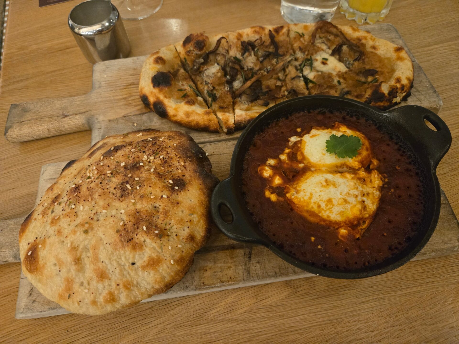 a pan of food next to a pizza