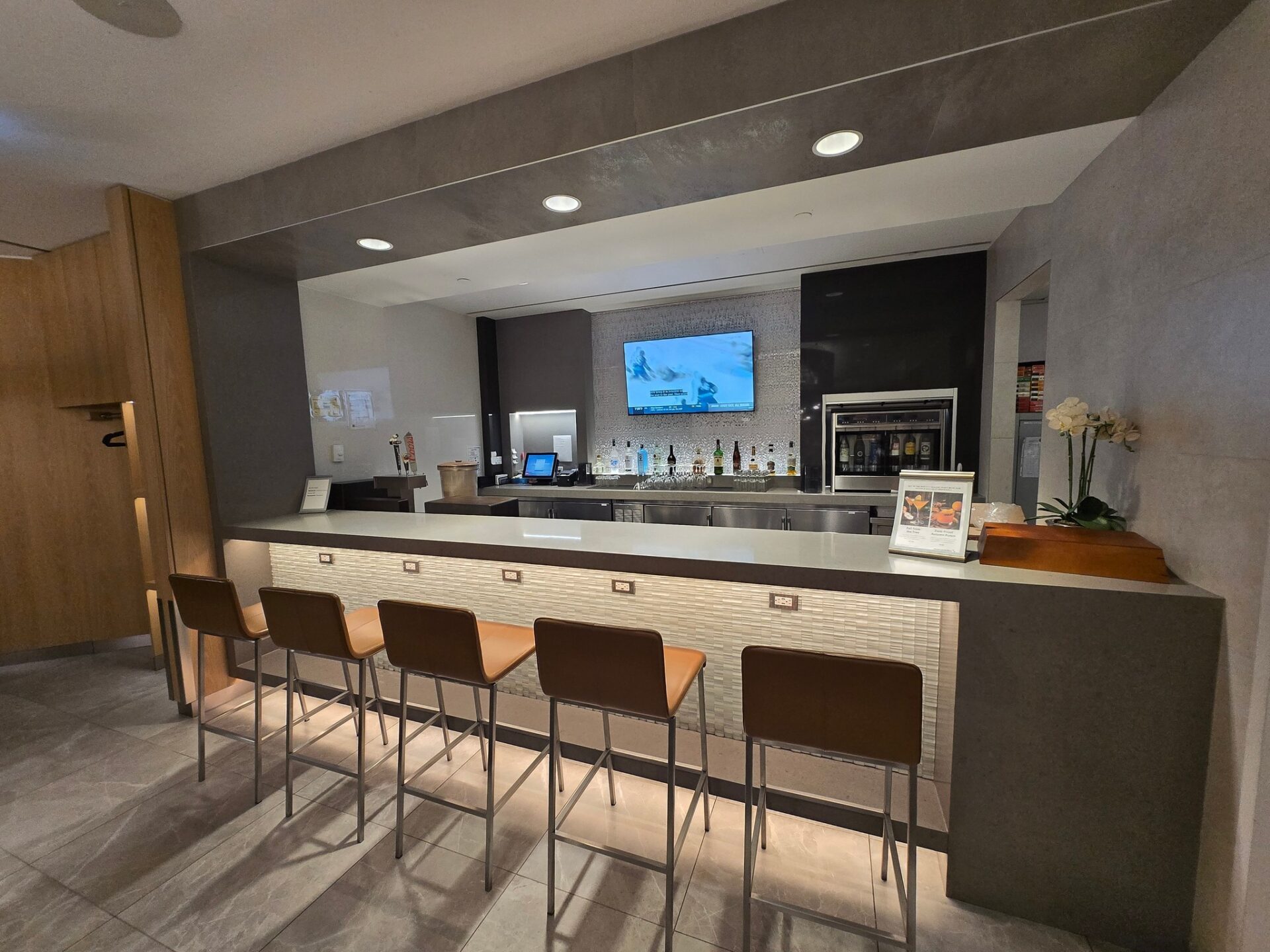 a bar with chairs and a television