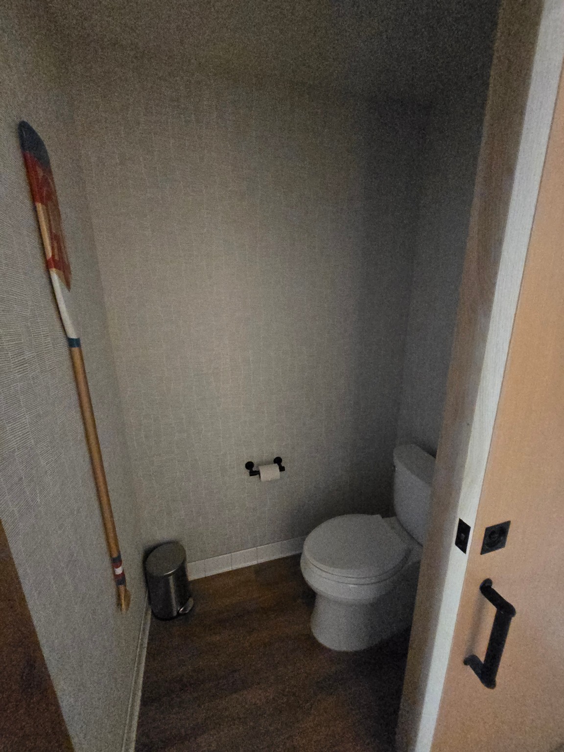 a toilet in a room with a hockey stick