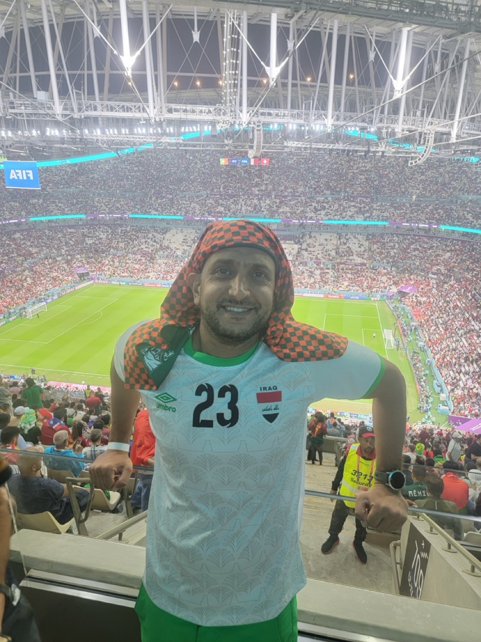 a man standing in a stadium with a football field and a crowd