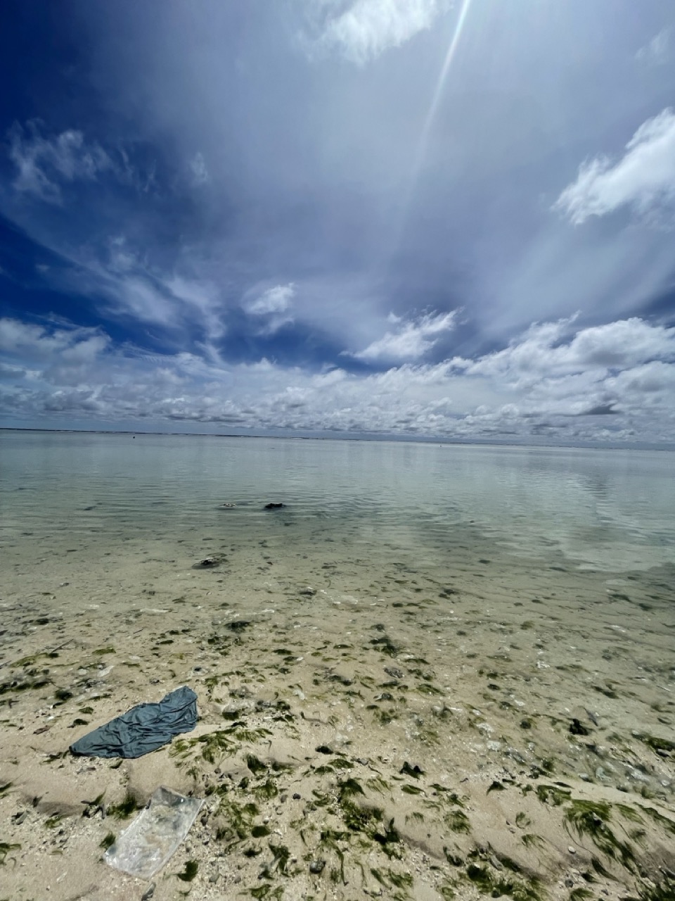 a body of water with a blue sky and clouds