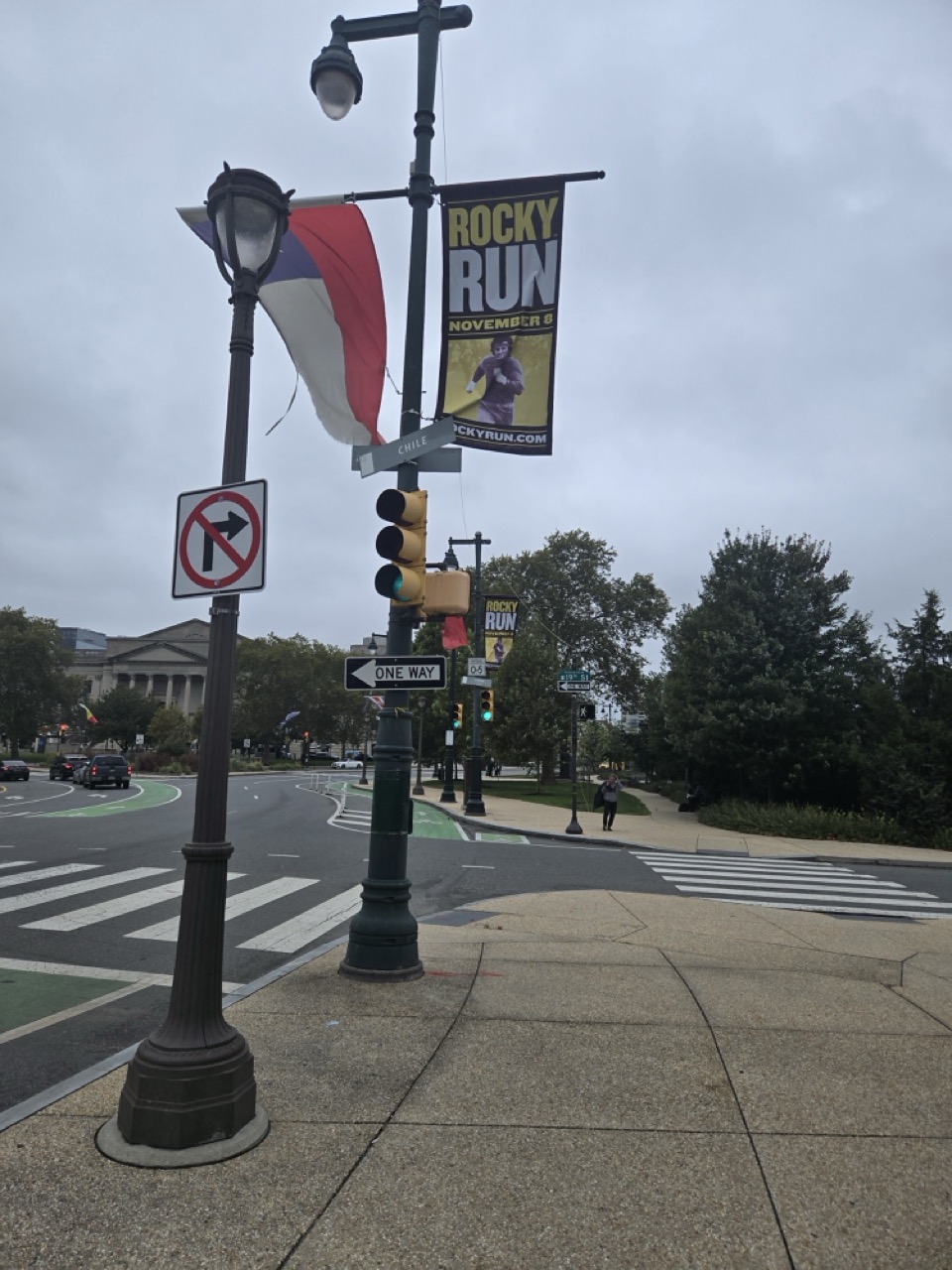 a street light with flags and signs on it