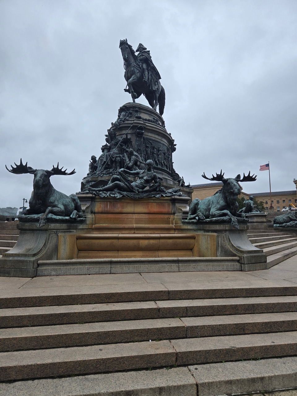 a statue of a man riding a horse on a pedestal with moose