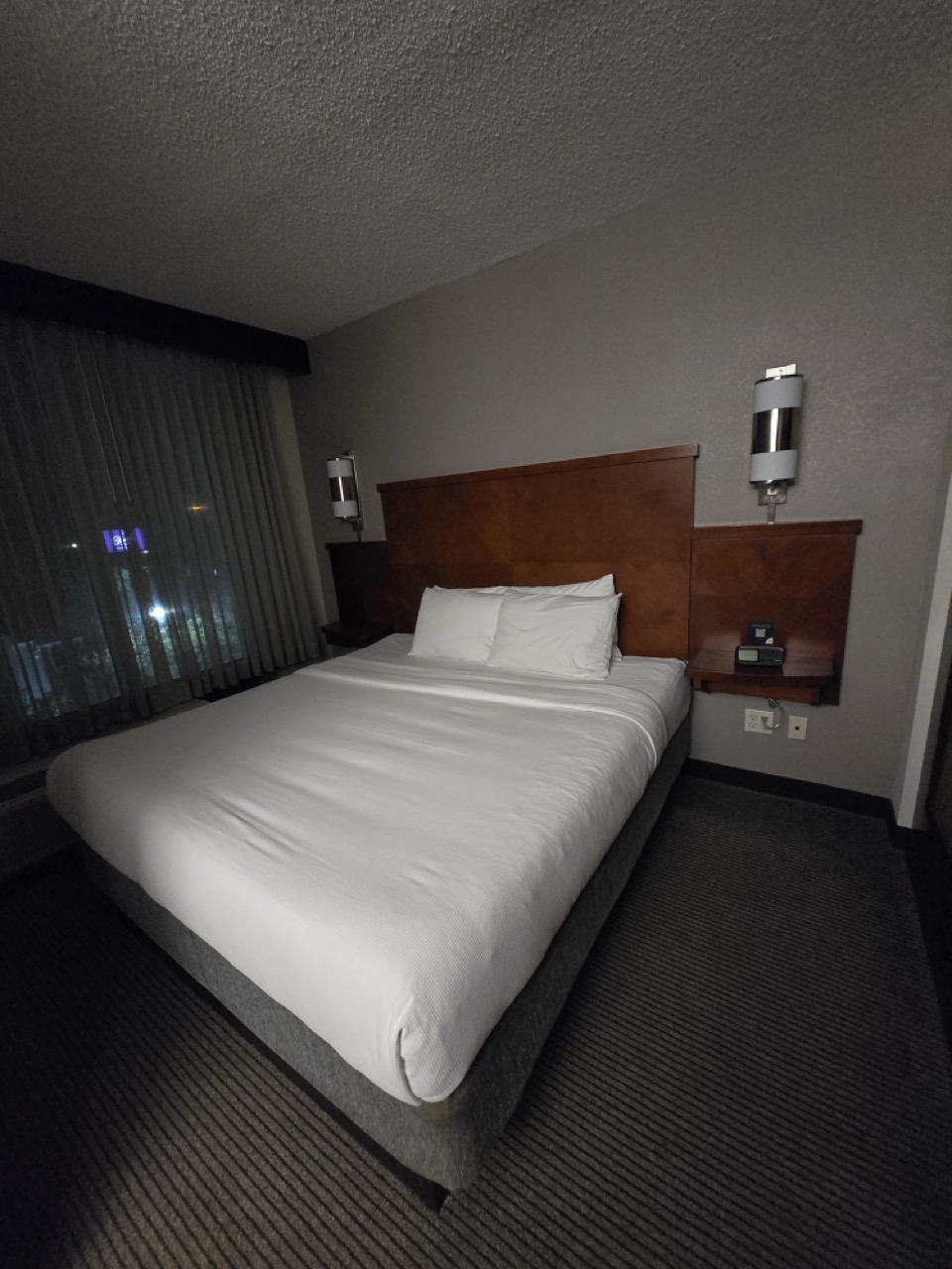 a bed with a wood headboard and two lamps