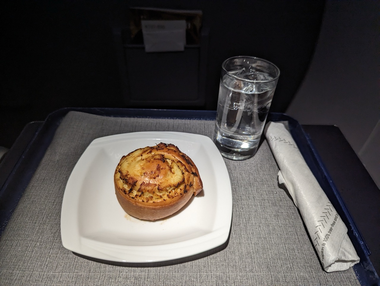 a plate of food and a glass of water on a tray