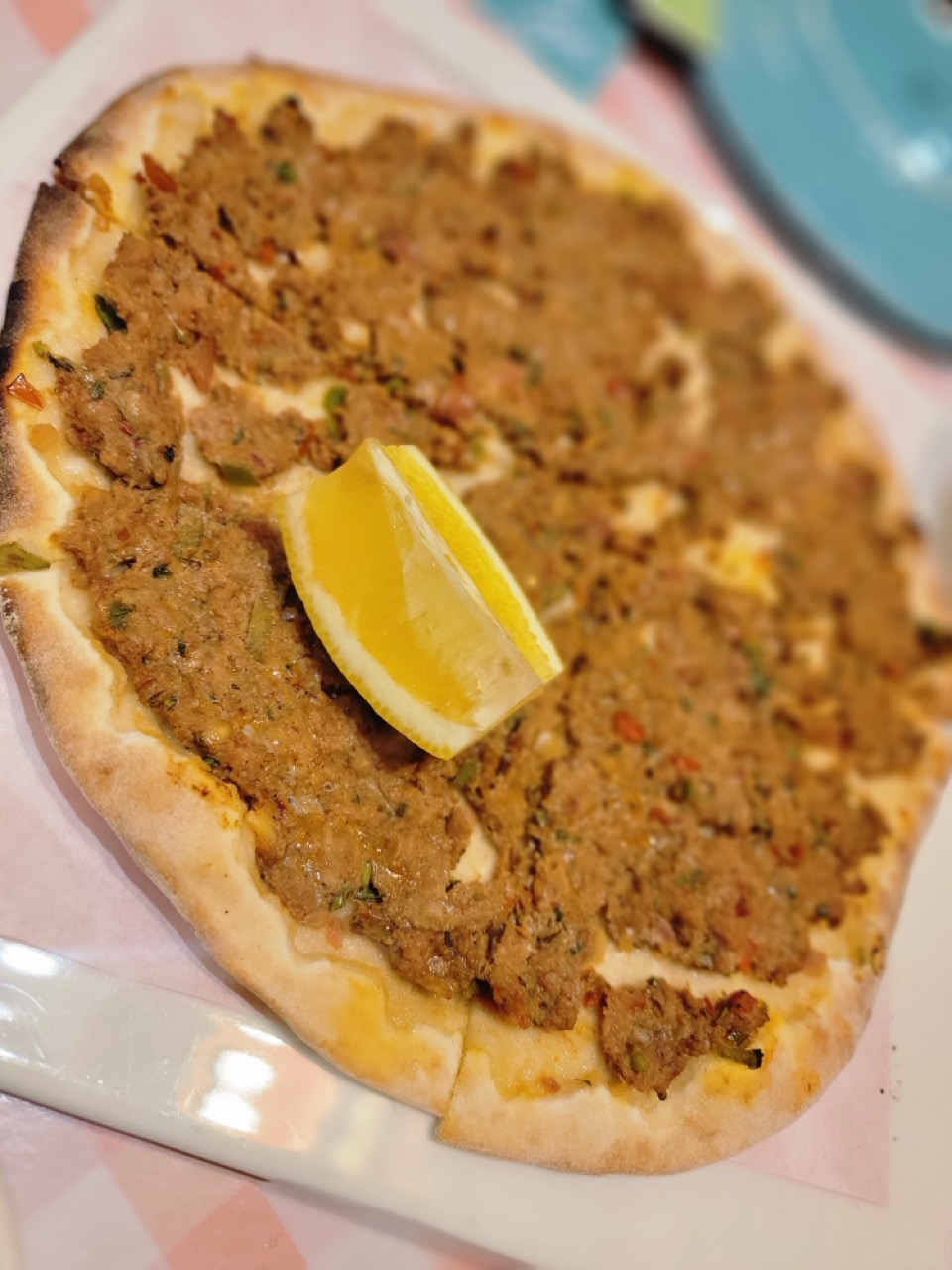 a pizza with a lemon wedge on top