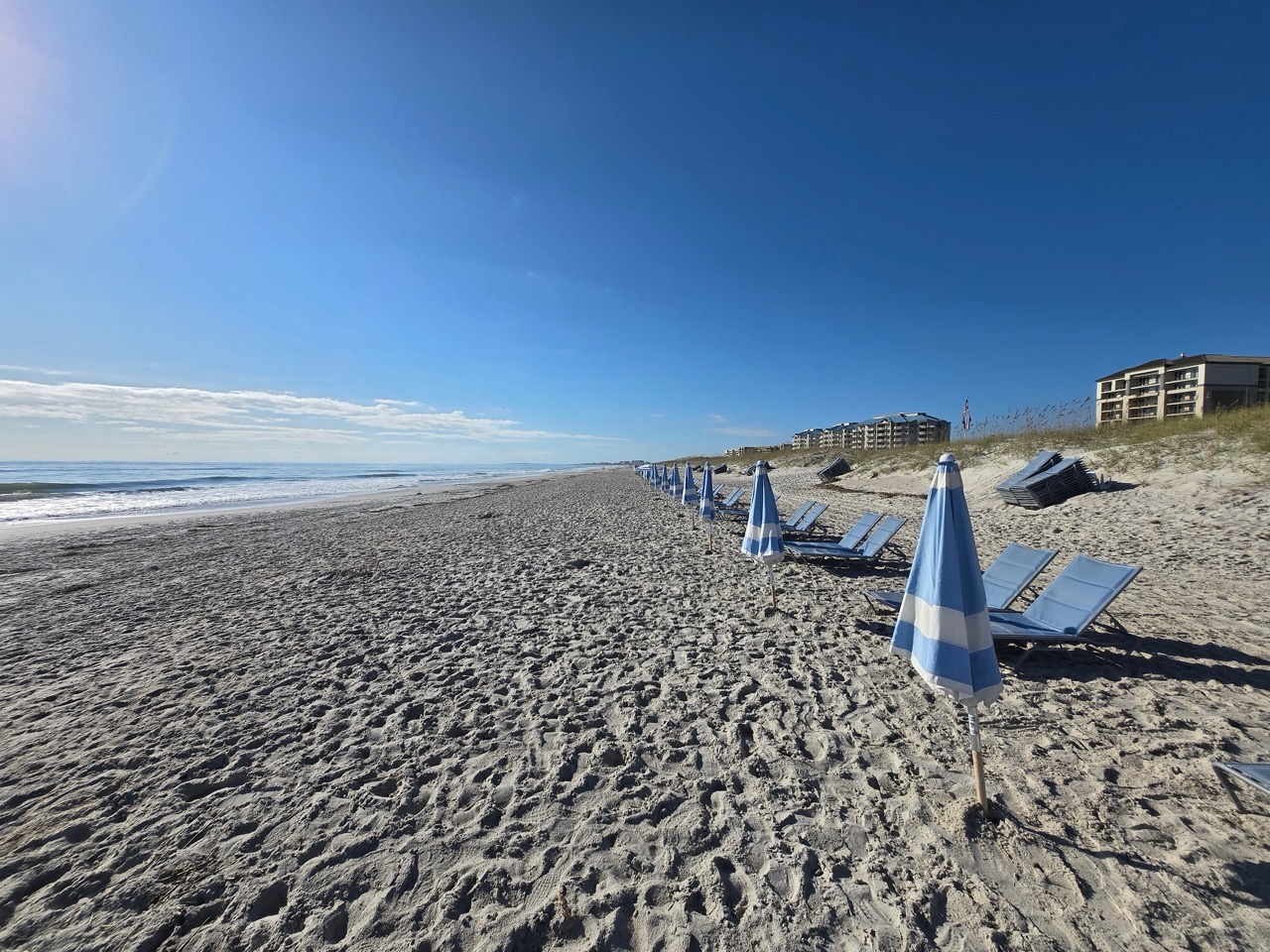 a beach with chairs and umbrellas